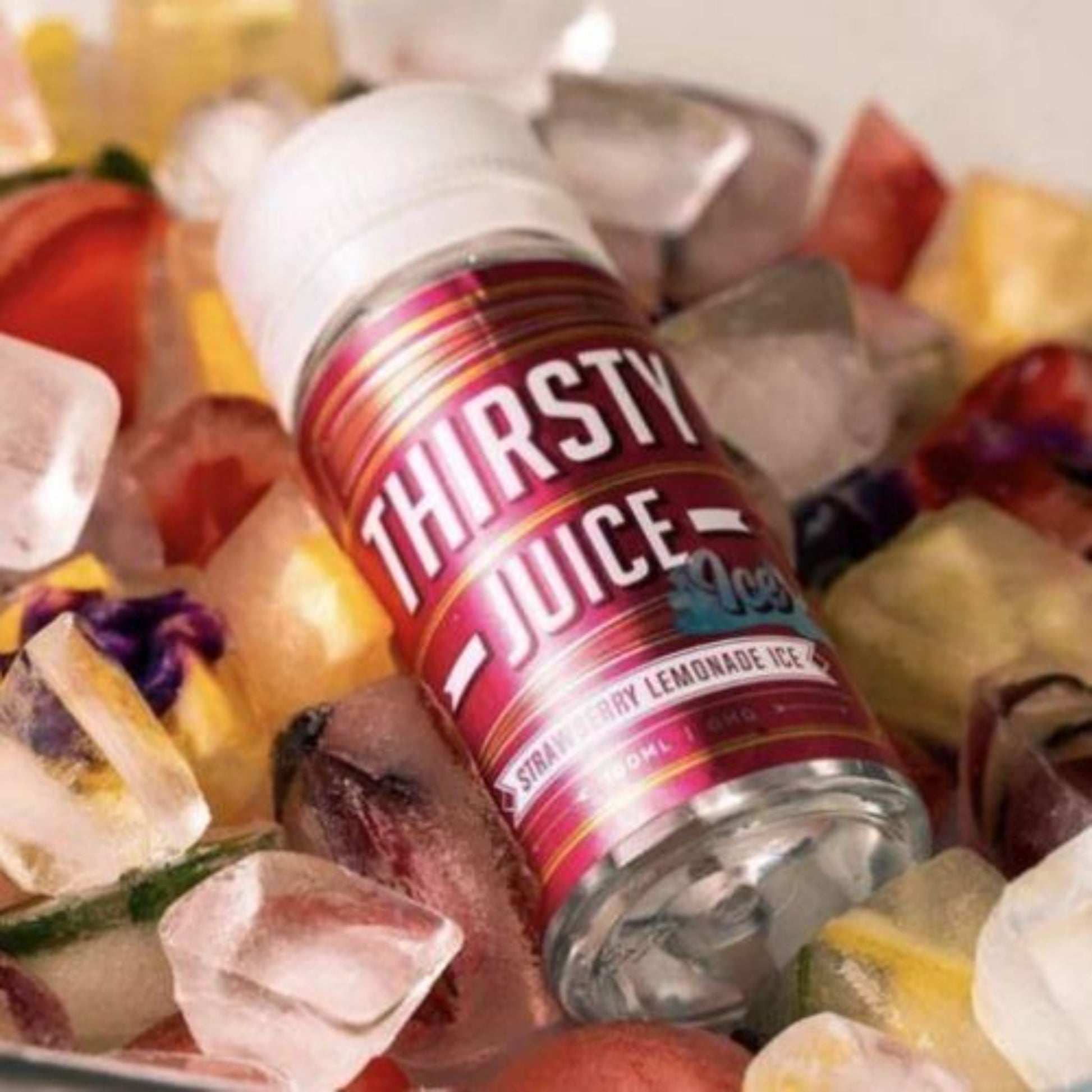 Thirsty Juice Co | Strawberry Lemonade Ice | 100ml bottle laying on a bed of frozen strawberries and lemons