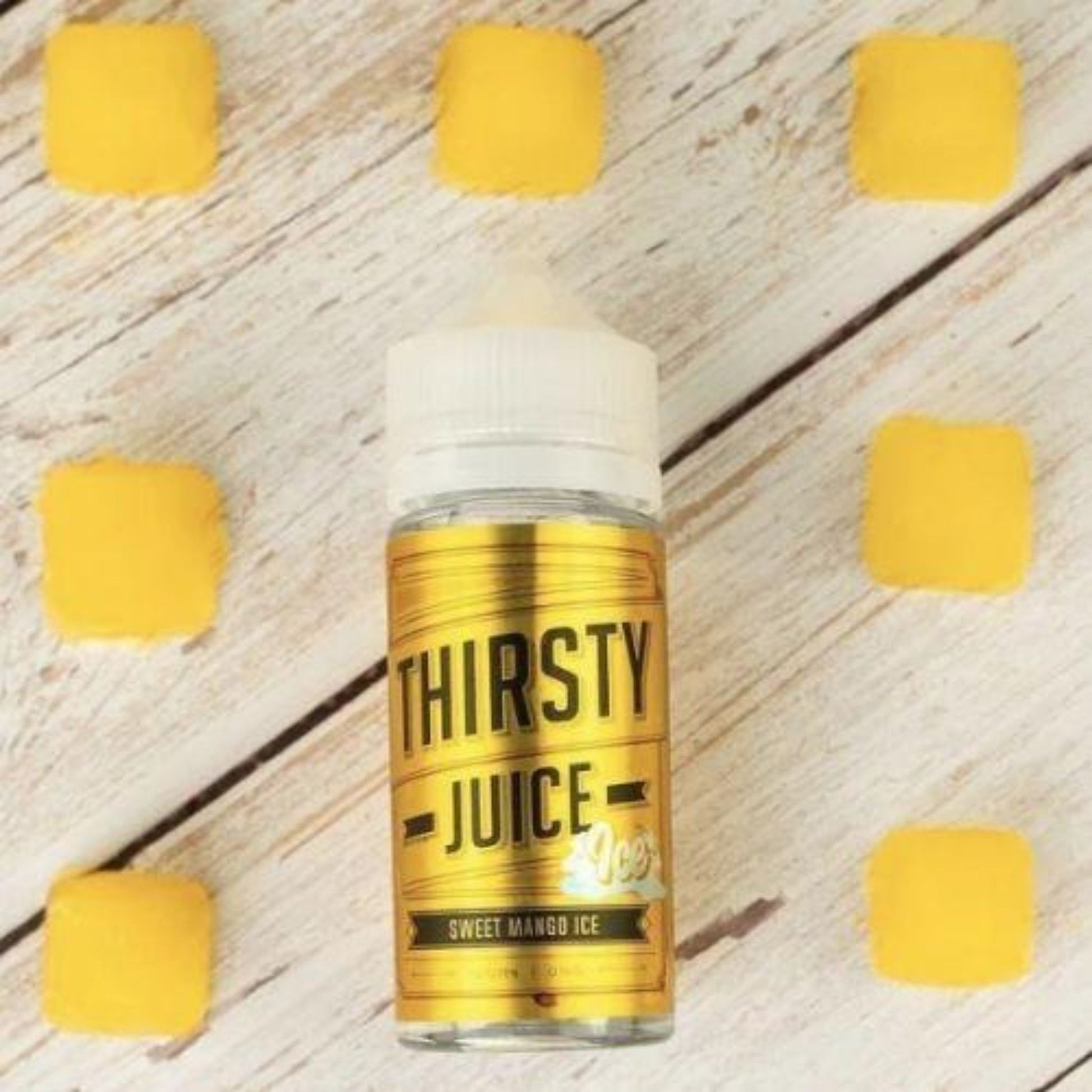 Thirsty Juice Co | Sweet Mango Ice | 100ml bottle laying on table with 7 mango ice cubes